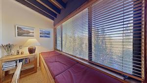 a room with a large window with a purple couch at Beautiful 4 Bed Condo with Top Of The Hill Views! in Mammoth Lakes