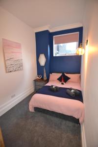 Schlafzimmer mit einem Bett mit blauer Wand in der Unterkunft Mayflower 2 bed Boutique Apartment - STAYSEEKERS in Salisbury
