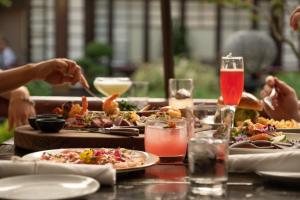 a group of people sitting at a table with plates of food at Hollywood Hills Hotel in Los Angeles