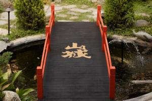 an orange bridge over a pond in a garden at Hollywood Hills Hotel in Los Angeles