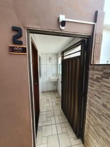 un corridoio con porta per un bagno con servizi igienici di Alberi Temporada Casas ad Arraial do Cabo