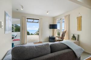 a living room with a couch and a large window at Ridge Top Views - Paekakariki Holiday Home in Paekakariki