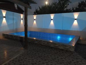 una piscina por la noche con luces en la pared en Casa VIRAMAR, en Barra del Chuy