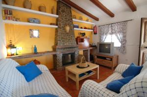 a living room with two couches and a fireplace at Cortijo Mirador Casitas Select in Frigiliana