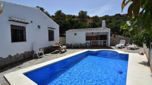 une villa avec une piscine en face d'une maison dans l'établissement Cortijo Antonio, à Nerja