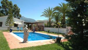 uma estátua ao lado de uma piscina num quintal em Villa Joaquin - Casitas Select em Nerja