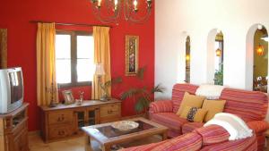sala de estar con sofá y TV en Villa Joaquin - Casitas Select, en Nerja