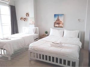 - une chambre avec 2 lits et des serviettes dans l'établissement Lullaby Residence, à Maha Sarakham