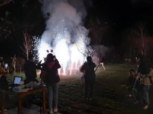 un grupo de personas tomando fotos de un espectáculo de fuego por la noche en 無盡夏民宿 en Nanzhuang