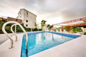 a swimming pool in front of a building at Vila Nikezić in Sutomore