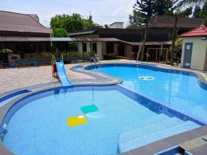 una grande piscina blu con scivolo di Hotel Bahtera PT.Pelni a Bogor