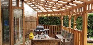 a wooden pergola with a grill on a wooden deck at Casas Condominio Pingueral in Dichato