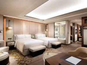 a bedroom with two beds and a living room at Raffles Shenzhen, Enjoy the daily happy hour in Long Bar, complimentary mini bar and welcome amenities in Shenzhen