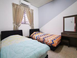 1 dormitorio con 2 camas, tocador y espejo en Bagan Terrace House near to Sunway Carnival Mall, Seberang Jaya en Butterworth