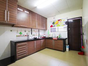 a large kitchen with wooden cabinets in a room at Bagan Terrace House near to Sunway Carnival Mall, Seberang Jaya in Butterworth