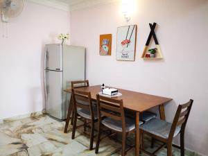 a dining room with a table and a refrigerator at Bagan Terrace House near to Sunway Carnival Mall, Seberang Jaya in Butterworth