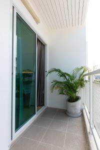 a balcony with a potted plant and a window at Matini Premium @ Klong 1 in Thanya Buri
