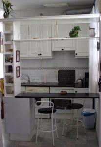 eine Küche mit weißen Schränken und einer schwarzen Arbeitsplatte in der Unterkunft One bedroom apartement with city view terrace and wifi at Sevilla in Sevilla