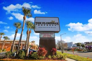 ein Zeichen für den internationalen mordaanischen Club mit Palmen in der Unterkunft Floridian Express International Drive in Orlando