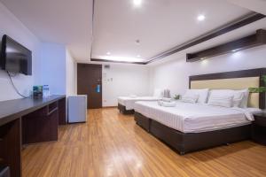 a bedroom with two beds and a flat screen tv at Initial Hua Hin - SHA Plus in Hua Hin +44 photos