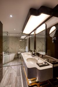 a bathroom with a large sink and a bath tub at Queen Elizabeth 2 Hotel in Dubai