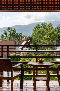 a dining room table with chairs and a patio at Phra Singh Village in Chiang Mai