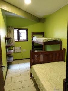 a room with two bunk beds and a staircase at Condominio Aldeia da Praia in Garopaba