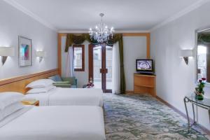 um quarto de hotel com duas camas e uma televisão em Makkah Towers em Meca