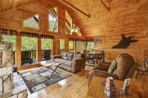 a living room with a fireplace in a log cabin at Spacious Cubby Bear Cabin in Sevierville