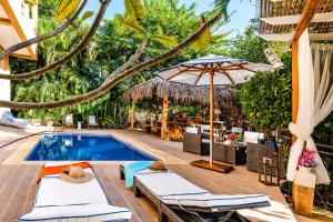 a pool with chairs and umbrellas next to a resort at Villa Nautilus in Tamarindo