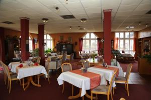 a restaurant with white tables and chairs and windows at Hotel Taunus Residence in Bad Camberg