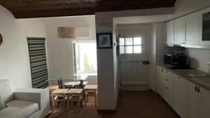 a kitchen and living room with a table and a couch at Casa Teresa in Évora