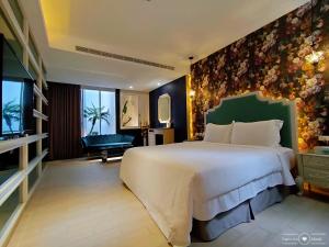 una camera da letto con un grande letto bianco in una stanza di 浪琴Motel文創旅館 a Taichung