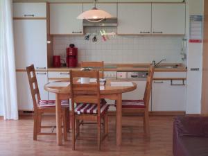 a kitchen with a wooden table with chairs and a kitchen counter at GODS06002-FeWo-bie-de-Reede in Gollendorf