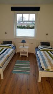 a bedroom with two beds and a window at GODS06002-FeWo-bie-de-Reede in Gollendorf