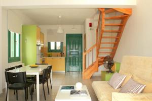 a living room with a table and a stairway at Ithaca's Poem Apartments in Vathi