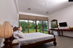 a bedroom with a bed and a large window at Iain Lake Winds Villa in Galle