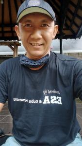 Un joven con sombrero y corbata de moño. en ESA di Kubu Homestay, en Singaraja