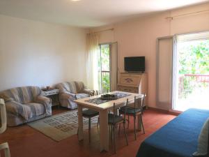 a living room with a table and chairs and a tv at Casa Romeo in Taormina