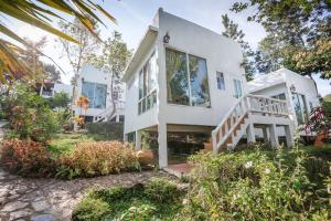 a white house with a staircase in a yard at Khao Kho Wanwarn in Phetchabun