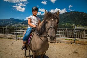 Uma jovem está sentada num cavalo. em Weidinghof em Sankt Veit im Pongau