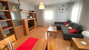 sala de estar con sofá y reloj en la pared en Apartamento Aluche con parking gratuito, en Madrid