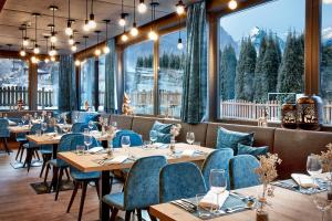 HOTEL SONNBLICK Kaprun, Salzburg - including Summer Card في كابرون: مطعم فيه طاولات وكراسي فيه جبال في الخلف
