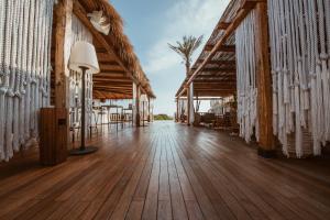 a hallway of a resort with tables and chairs at Cumeja Beach Club & Hotel in Baia Domizia