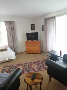 a living room with a tv and a couch and a dresser at Sakabula Country Lodge in Camperdown