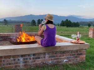 a woman sitting on a brick wall drinking a glass of wine at Belvidere Country Estate in Yarrow