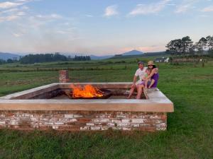 a group of three people sitting around a fire pit at Belvidere Country Estate in Yarrow