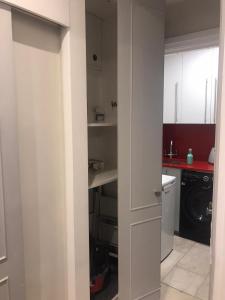 uma cozinha com armários brancos e um fogão em Modern Studio Apartment em Londres