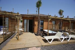 een terras met stoelen en een tafel en palmbomen bij Magic Natura Resort in Benidorm