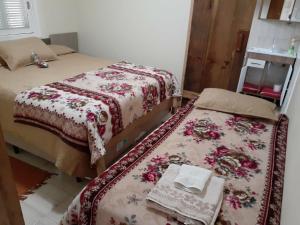 a bedroom with two beds and a table with a blanket at Estalagem Santa Fé in Cambara do Sul